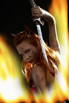 dark red devil girl with a knife in burning fire