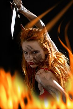 dark red devil girl with a knife in fire