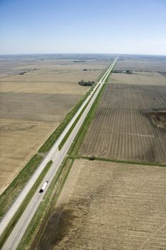 Aerial view of highway through rural farmland with crops.