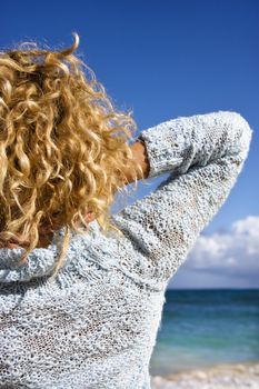 Portrait of woman standing on Maui, Hawaii beach looking at ocean.