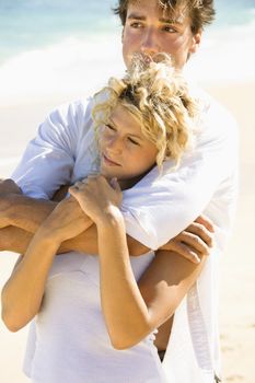 Couple embracing on Maui, Hawaii beach.