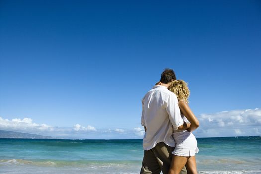 Attractive couple in embrace on Maui, Hawaii beach.