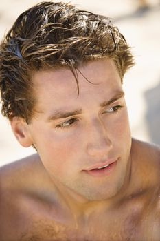 Head and shoulder portrait of handsome man on beach.