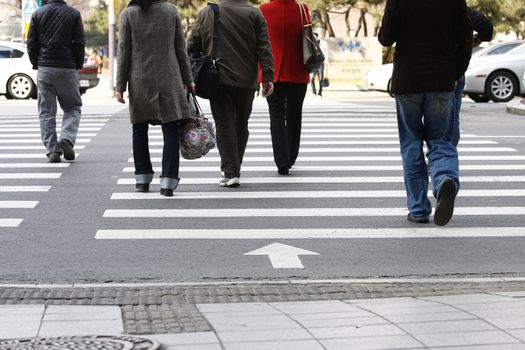 Cross walkers on a busy highway rush hour at city intersection