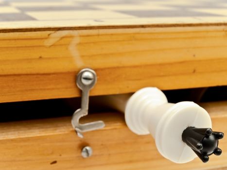 white king in wooden chess home with hook
