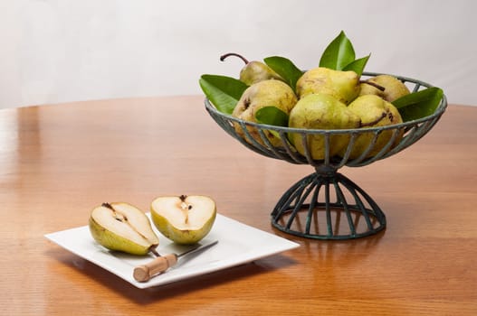 Fresh yellow pears in a basket on a wooden table