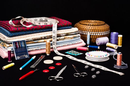 Sewing accessories and fabric on a black background