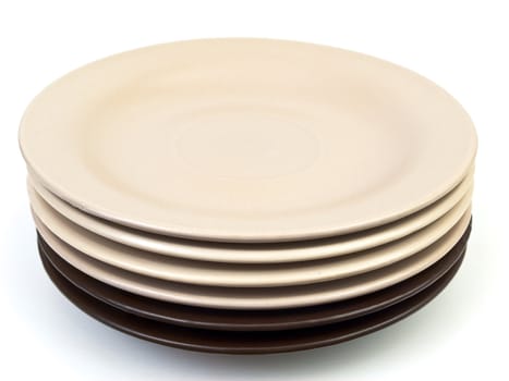 beige and brown saucers against the white background 