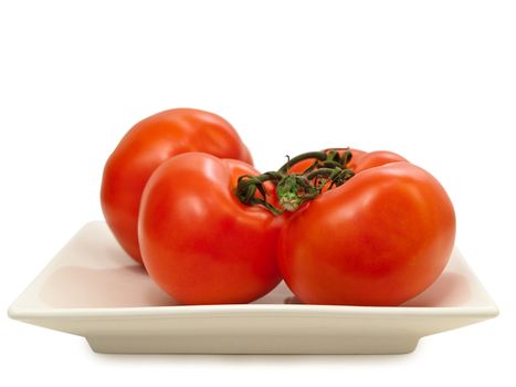 red tomatoes vine in plate against the white background