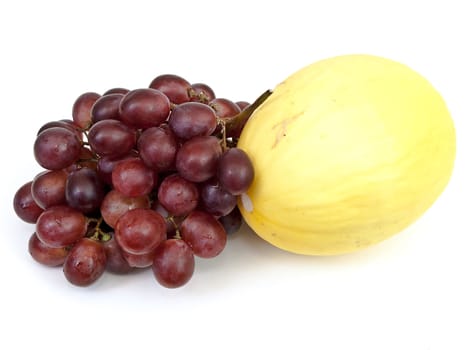 Photo of the yellow melon and grape against the white background