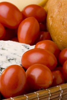 Slice of the Danish blue cheese with a mould among tomatoes.