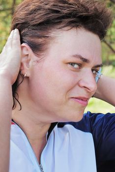 The beautiful   sportswoman corrects hair by hands