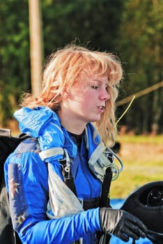 The girl parachutist in blue overalls on airfield