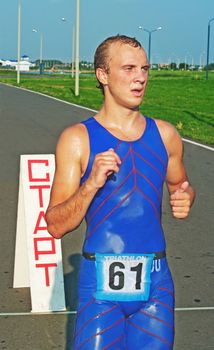 finish of triathlon  competition participant in blue overalls