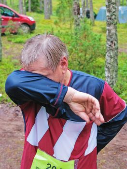 the sportsman  after running finish wipes the face a hand