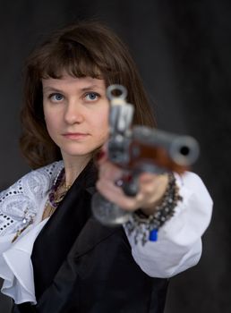 The girl - pirate with ancient pistol in hand on a black background