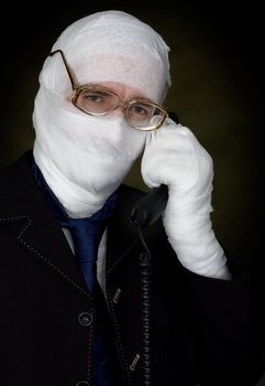 Man in bandage with eyeglasses  calling on phone