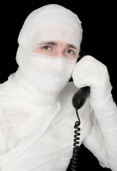 Mummy-businessman talking on telephone on the black background