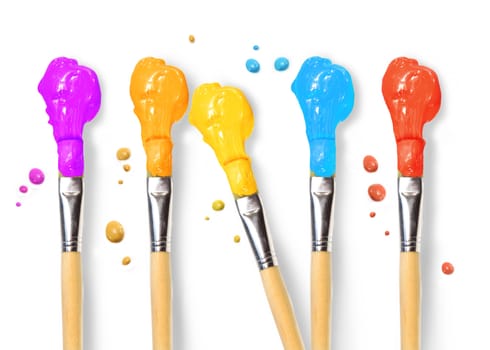 Bristle brushes full of different colored paints on white