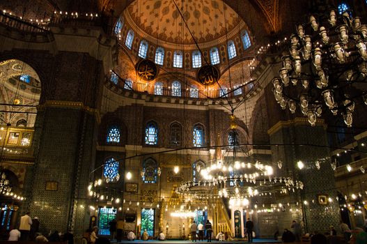 Moslems performing their prayer in the gorgeous Yeni Camii mosque in Istanbul, Turkey
