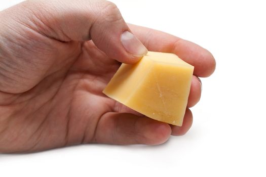 Piece of the cheese in hand on white background