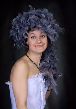 Portrait of the beautiful girl with a boa on a head