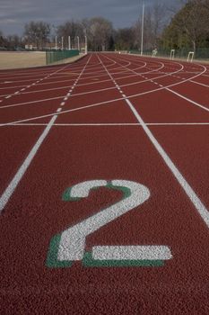 white lane number two at a starting line red running tracks