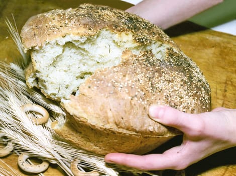 Breaking potato bread with sesame seeds