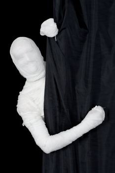 Man in bandage looking from behind of curtain