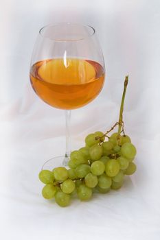 Still-life with a glass of wine and grapes on a white background