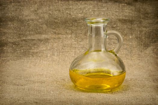 Carafe with yellow oil on canvas background