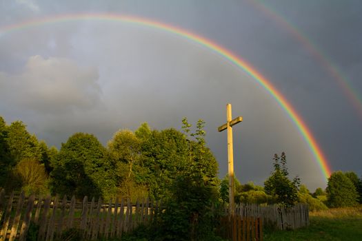 cross and rainbow after summer rain