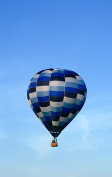 Blue hot air balloon in the evening sky.