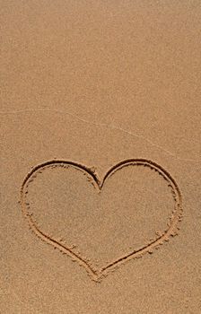 Heart symbol drawn in the sand beach, with copy-space.