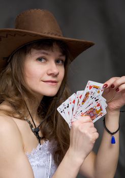 Portrait girl with a playing-cards in hand on black