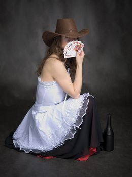 Girl with a playing-cards in hand on black