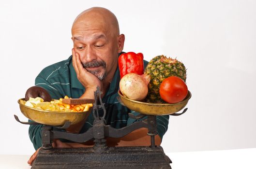 Dieting man anxiously looking at what he should not eat