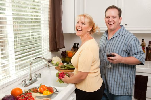 Happy Couple Enjoying An Eveing Preparing Food in the Kitchen.