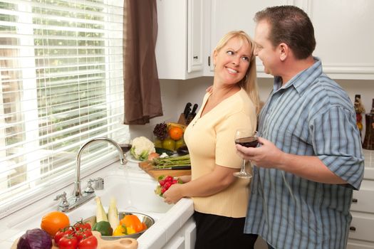 Happy Couple Enjoying An Eveing Preparing Food in the Kitchen.