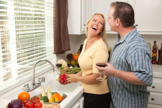 Happy Couple Enjoying An Eveing Preparing Food in the Kitchen.