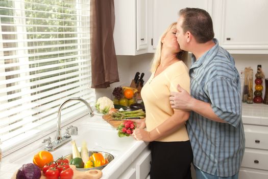 Happy Couple Enjoying An Eveing Preparing Food in the Kitchen.