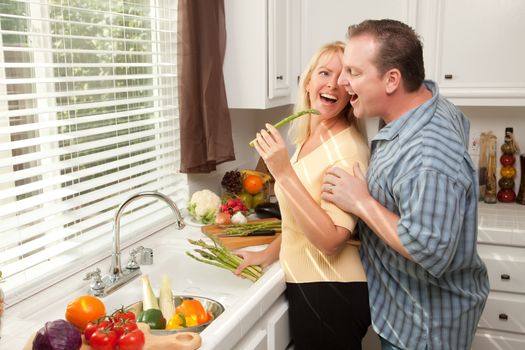 Happy Couple Enjoying An Eveing Preparing Food in the Kitchen.