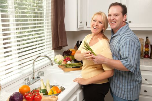 Happy Couple Enjoying An Eveing Preparing Food in the Kitchen.