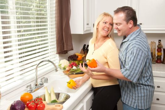 Happy Couple Enjoying An Eveing Preparing Food in the Kitchen.