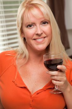 Attractive Blond with a Glass of Wine in the Kitchen