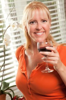 Attractive Blond with a Glass of Wine in the Kitchen