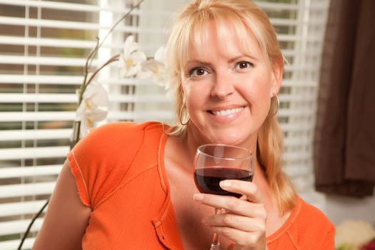 Attractive Blond with a Glass of Wine in the Kitchen