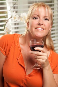 Attractive Blond with a Glass of Wine in the Kitchen