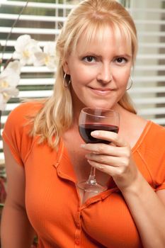 Attractive Blond with a Glass of Wine in the Kitchen