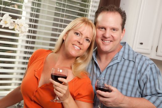 Happy Couple Enjoying a Glass of Wine the Kitchen.